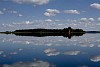 Island on silent lake with bonfire