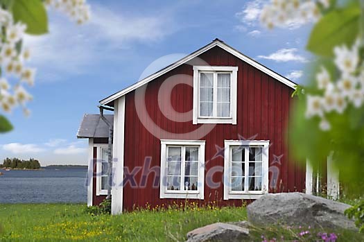 Old red wooden cottage by the sea