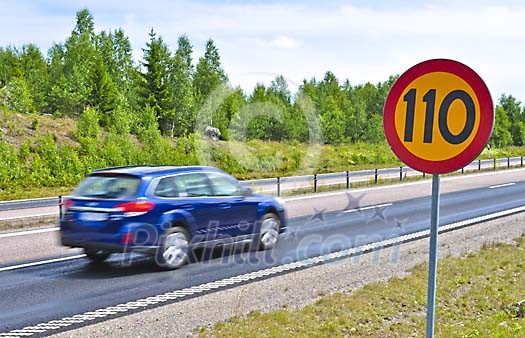 Motion blur car passing a speed limit sign on a Swedish highway Motion blur car passing a speed limit sign on a Swedish highway