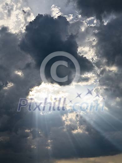 Sun beams shining through dark clouds