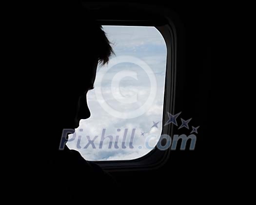 Silhouette of a human face by airplane window