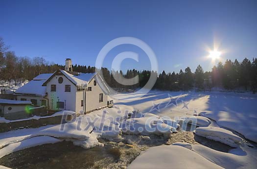 House next to a river on a sunny winter day