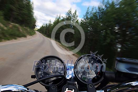 Speeding motorcycle on a forest road