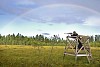 Hunter aiming under the rainbow
