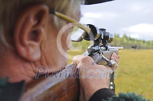 Hunter aiming a moose Hunter aiming a moose