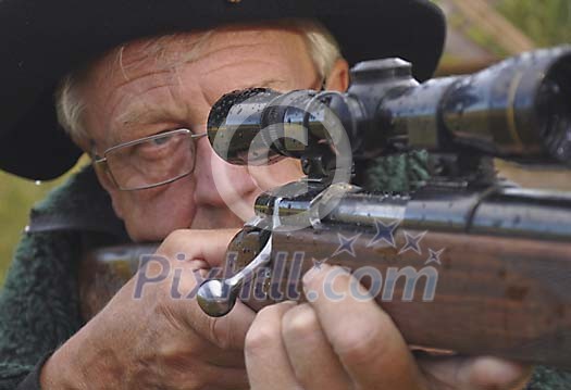 Close-up of a hunter aiming with a rifle