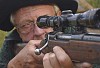 Close-up of a hunter aiming with a rifle