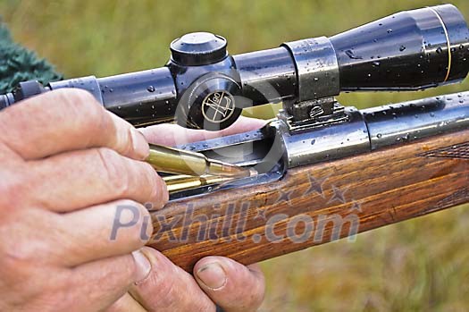 Hunter loading a rifle