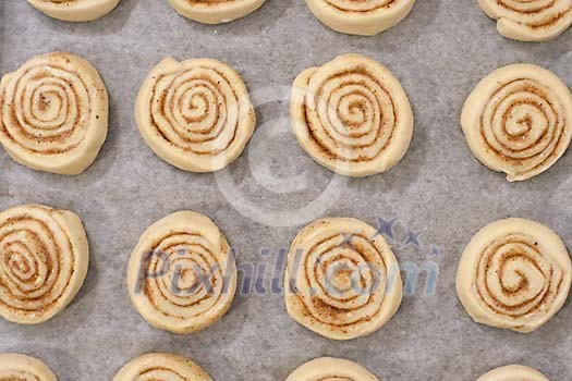 Raw cinnamon rolls on the pan Raw cinnamon rolls on the pan