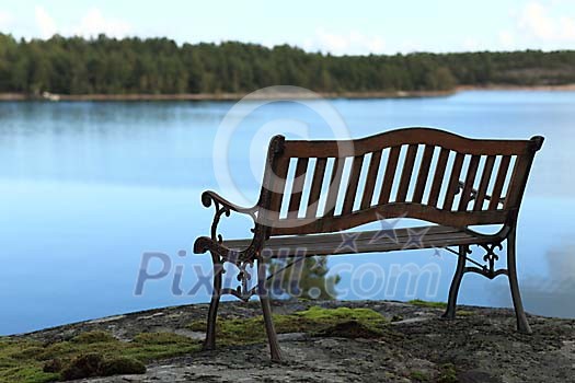 Empty bench by the water