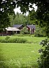 Idyllic wooden houses and green summer meadow