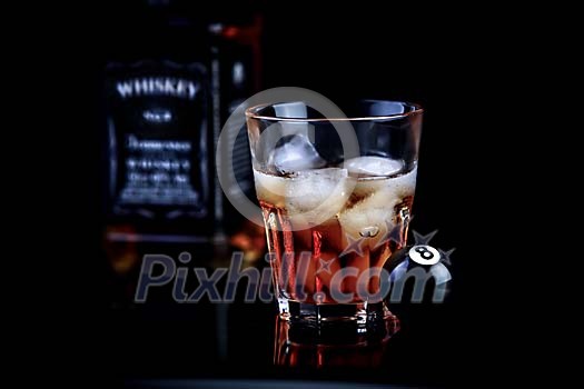 Glass of whisky with a billiard ball