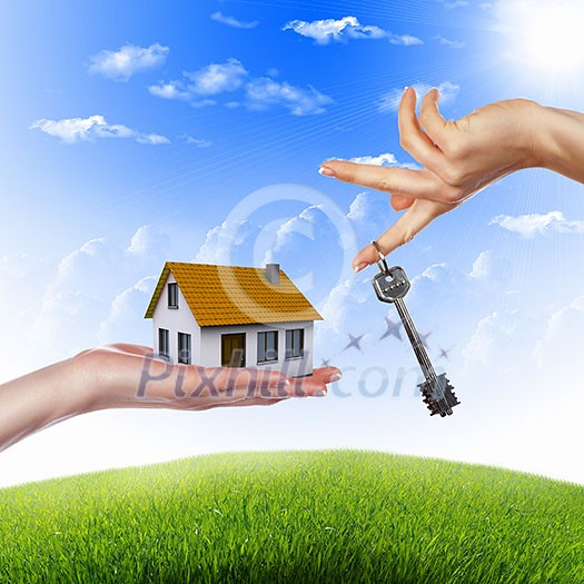 Human hand against blue sky background and house Human hand against blue sky background and house