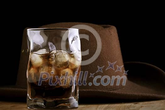 Dark drink with a hat on the background