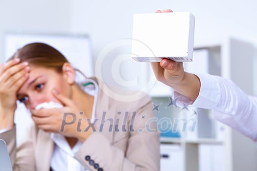 Young woman in office holding a pack of medicine Young woman in office holding a pack of medicine