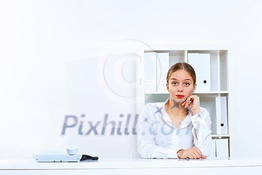 Young woman in business wear sitting with a phone in office Young woman in business wear sitting with a phone in office