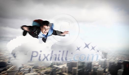 Conceptual image of young businessman flying with parachute on back Conceptual image of young businessman flying with parachute on back