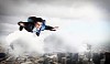 Conceptual image of young businessman flying with parachute on back