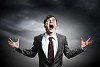 Businessman in anger with fists clenched screaming