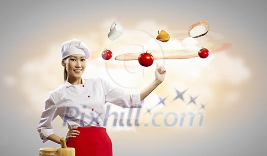 Asian female cook making pizza standing against color background