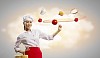 Asian female cook making pizza standing against color background