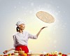 Asian female cook making pizza standing against color background