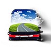 Red suitcase with green landscape and country road inside