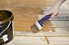 Male hand with a brush painting the floor