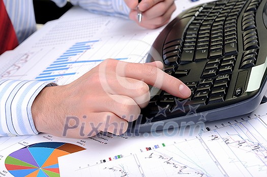 A young business man working in an office at his workplace. A young business man working in an office at his workplace.