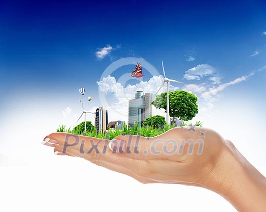 human hand holding a city on green grass hill human hand holding a city on green grass hill