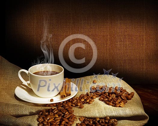 Steaming cup of coffee, cinnamon sticks and a few coffee beans. still life