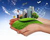 human hand holding a city on green grass hill