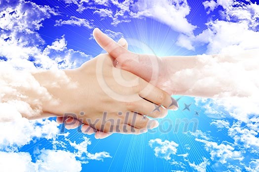 Handshake of two business people against the sky. Symbol of successful business