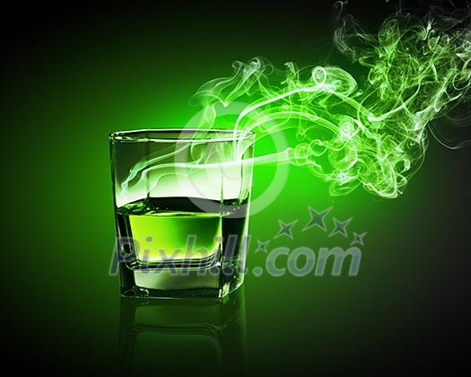 Glass of green absinth with fume going out