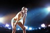 Fitness woman standing against stadium lights background