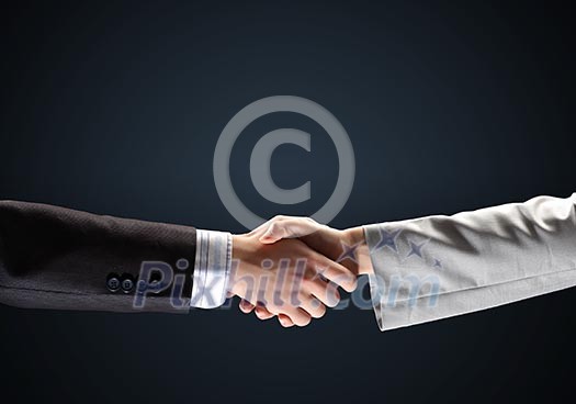 image of business handshake against black background