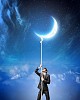 Image of businessman climbing rope attached to moon