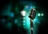 Single retro microphone against colourful background with lights