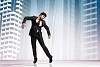 Image of businessman hanging on strings like marionette against city background. Conceptual photography