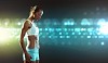 Fitness woman standing against color lights background