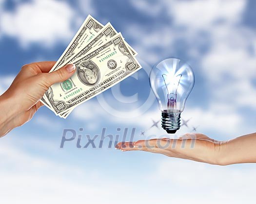 Human hands with money and electric bulb against blue sky Human hands with money and electric bulb against blue sky
