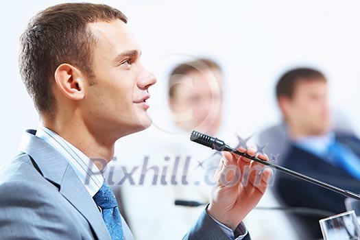 Image of three businesspeople at table at conference