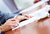 Image of businessman's hands signing documents at meeting