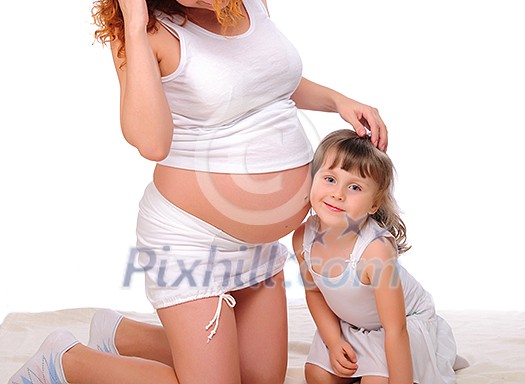 Young redhead pregnant mother spends time with her daughter