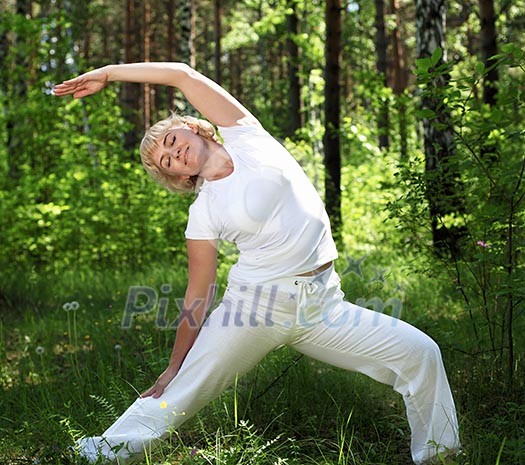 An elderly woman practices yoga in nature. The symbol of healthy lifestyle An elderly woman practices yoga in nature. The symbol of healthy lifestyle
