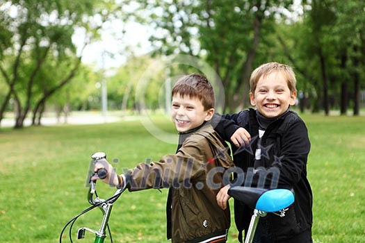 Happy smiling boy on a bicycle in the green park