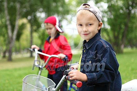 Happy smiling boy on a bicycle in the green park