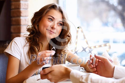 Young couple with a ring during an engagement in a restaurant Young couple with a ring during an engagement in a restaurant