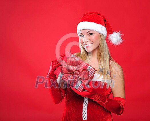 Portrait of a young charming girl dressed as Santa with a gift in their hands. Happy New Year!