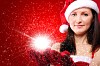 Portrait of a young girl dressed as Santa Claus on a red background. Girl gives gifts. Happy New Year and Merry Christmas!